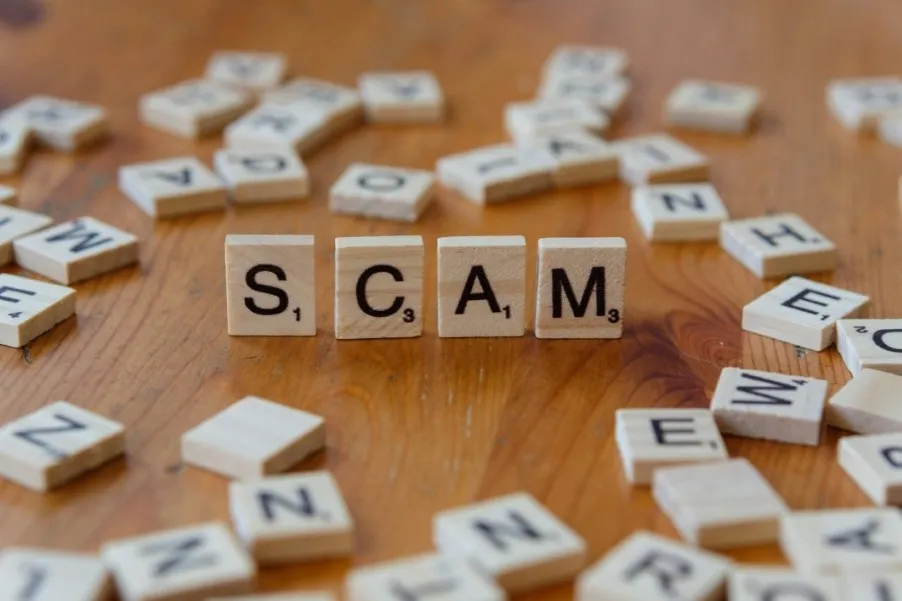 Scrabbler letters forming the word "SCAM"
